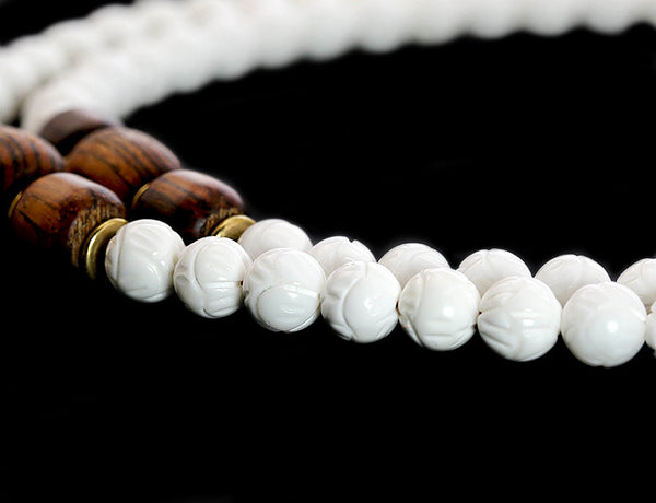 Buddhist Mala Beads with Carved Shell and Bocote Wood Close Up.
